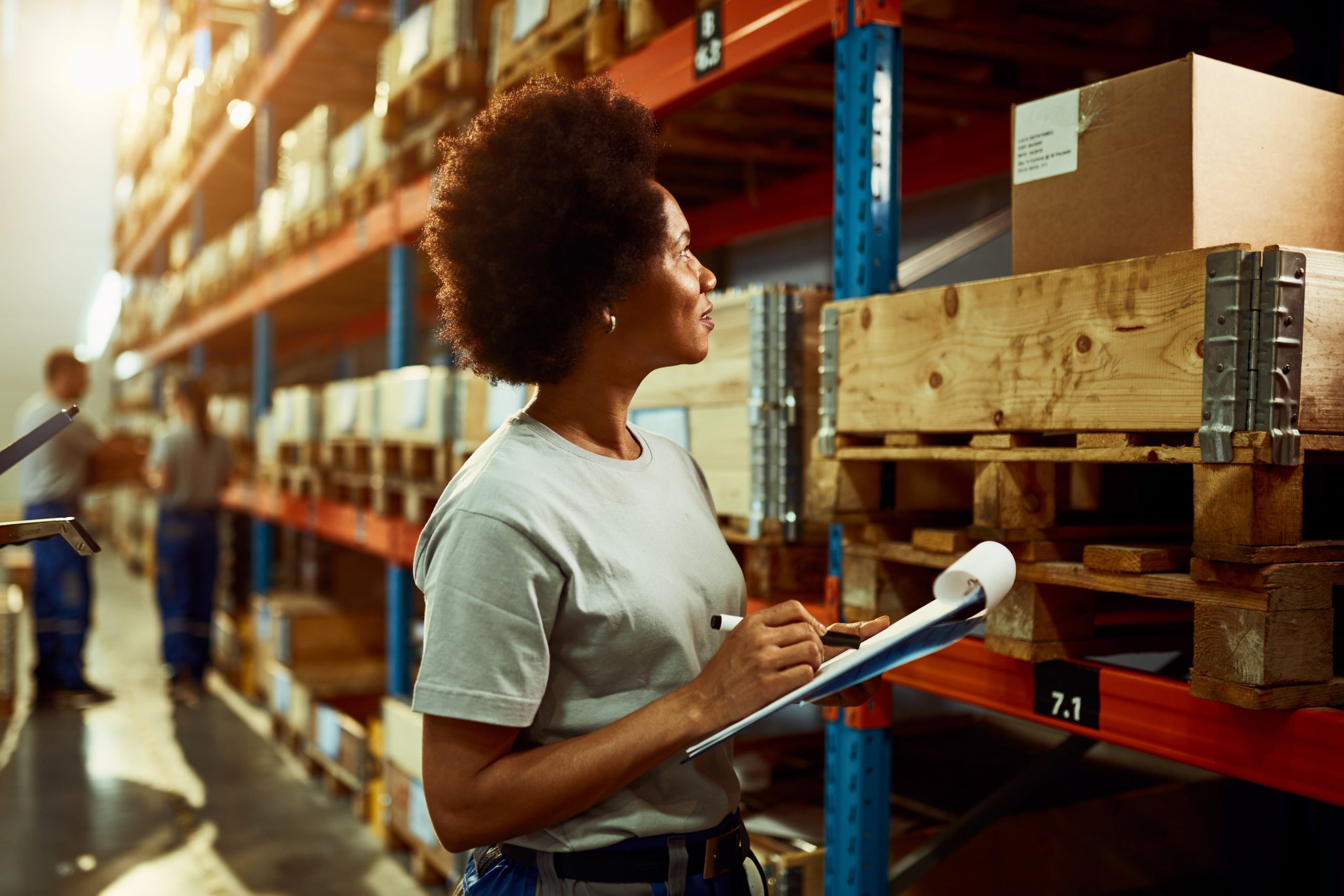 african-american-worker-writing-inventory-list-while-checking-stock-storage-room-min